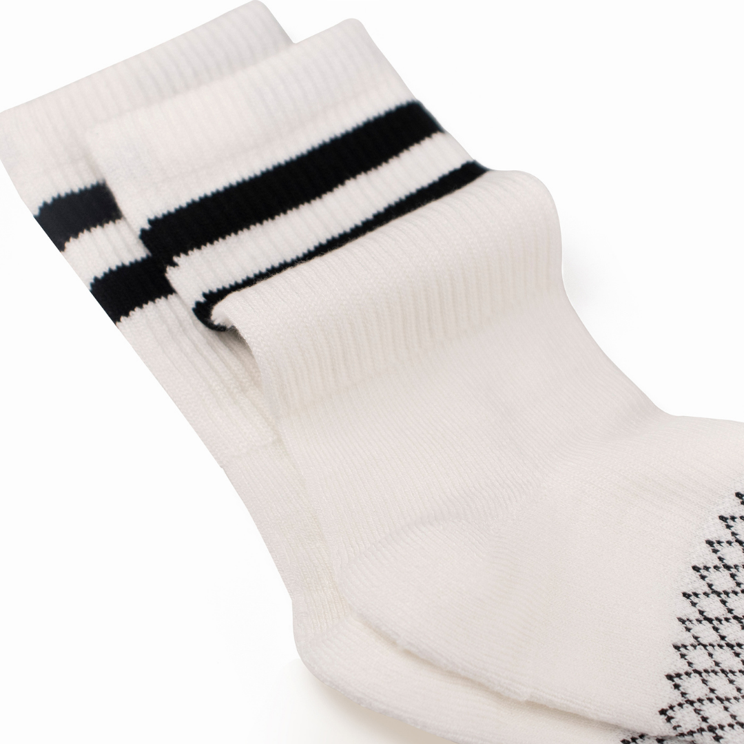 Folded view showing solid white crew compression socks with double black cuff stripes.