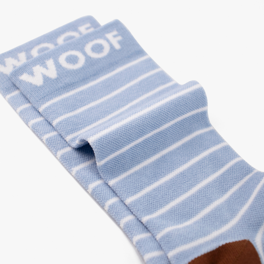 Folded view showing cute wombat illustration on light blue striped bamboo crew compression socks with wombat design.