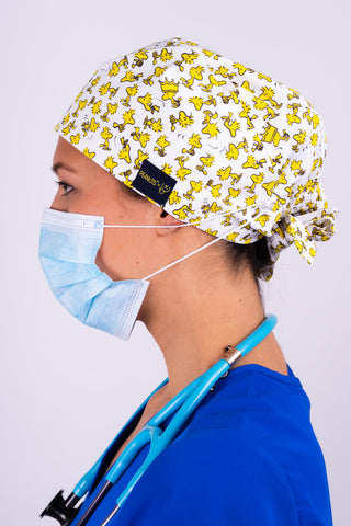 A Nurse Wearing a Dr. Woof Peanuts Woodstock Surgical Scrub Cap