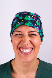 A Vet Wearing a Dr. Woof Peanuts Aloha Disco Surgical Scrub Cap