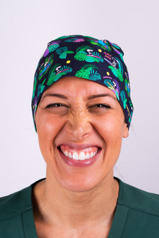 A Vet Wearing a Dr. Woof Peanuts Aloha Disco Surgical Scrub Cap