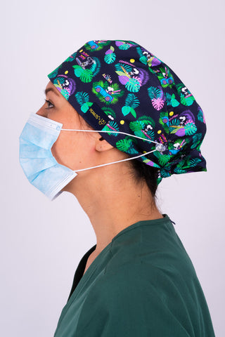 A Nurse Wearing a Dr. Woof Peanuts Aloha Disco Surgical Scrub Cap