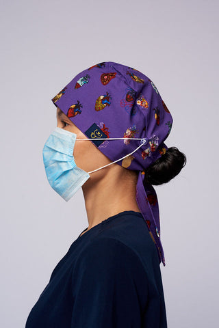 A doctor wearing a Dr. Woof 15 Hearts by Sarai Llamas Surgical Scrub Cap 