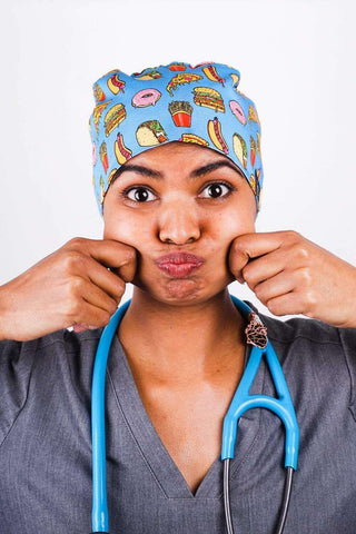 A Nurse Wearing a Dr. Woof Junk Food Surgical Scrub Cap Tie Back